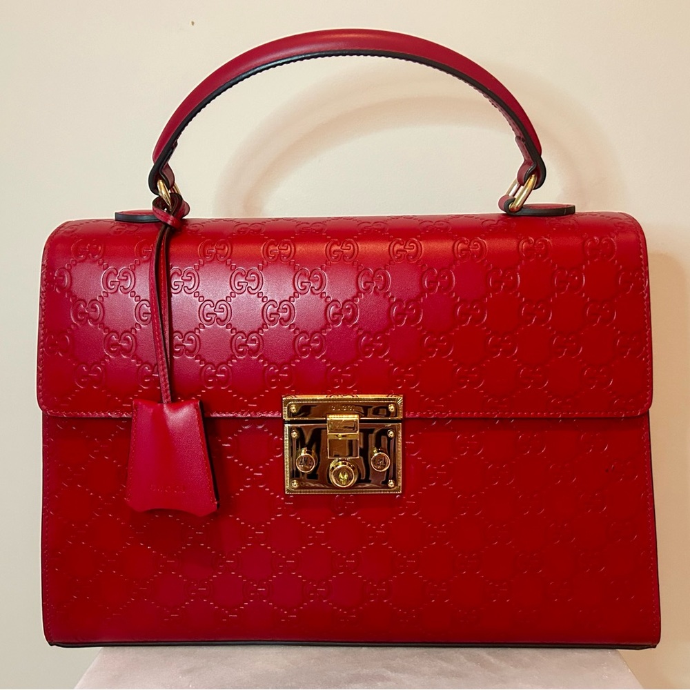 GUCCI 
Guccissima Signature Padlock Top Handle Bag Hibiscus Red